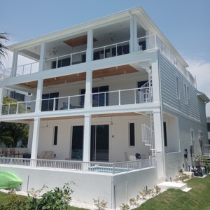 exterior cable railing balconies on luxury waterfront home installed by AMD Ornamental LLC railing contractor serving Naples Marco Island Bonita Springs Estero Fort Myers and Cape Coral Florida